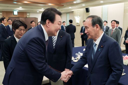 윤석열 대통령이 17일 도쿄 시내의 한 호텔에서 열린 일한의원연맹 및 일한친선협회 중앙회 접견에서 일한의원연맹 회장에 취임하는 스가 요시히데 전 총리와 악수하고 있다. 뉴시스