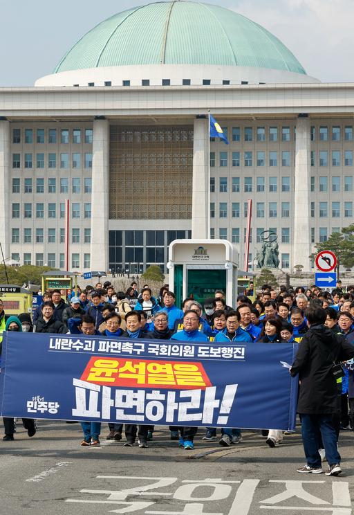 더불어민주당 의원들이 16일 서울 여의도 국회에서 ‘대통령 파면촉구 국회의원 도보행진’을 하며 광화문으로 향하고 있다. 뉴스1