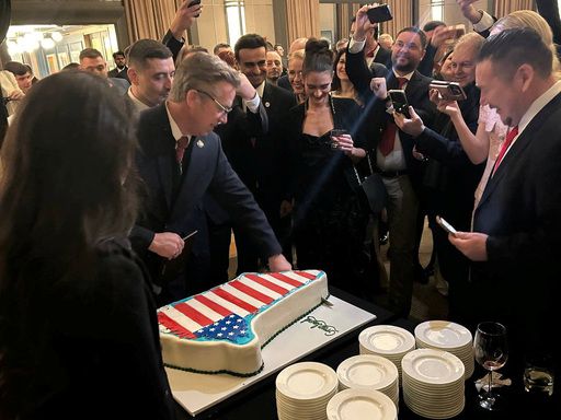 지난 20일(현지시간) 미국 수도 워싱턴의 케네디 센터에서 신년 행사가 열린 가운데 참석자들이 덴마크령 그린란드 지도에 미국 국기인 성조기 문양을 입힌 대형 케이크를 보며 환호하고 있다. 케네디 센터는 도널드 트럼프 대통령이 직접 이사장을 맡고 있는 공연장으로, 지난 2025년 말 ‘트럼프·케네디 센터’로 개명됐다.