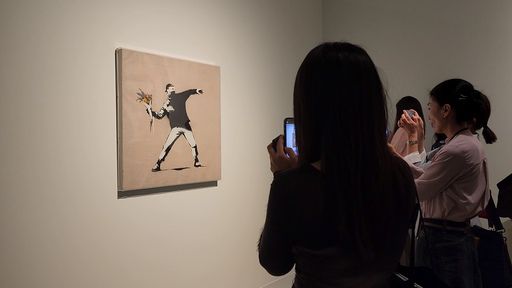 관람객이 뱅크시의 ‘사랑은 공중에’를 감상하고 있다. 사진=정희원 기자