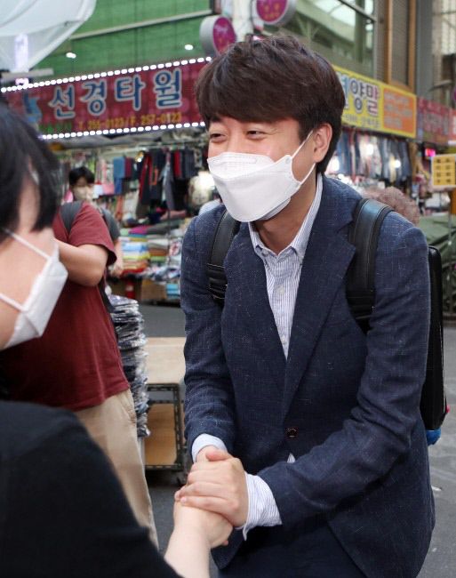 지난 5월24일 국민의힘 당대표 선거 운동을 위해 대구 중문 서문시장을 찾은 이준석 대표가 상인과 인사를 하고 있다. 연합뉴스