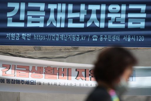 정부가 긴급 지원이 필요한 280만 가구를 대상으로 긴급재난지원금을 현금 지급한 지난 5월4일 서울 종로구의 한 주민센터에 걸린 현수막.(사진=연합뉴스)