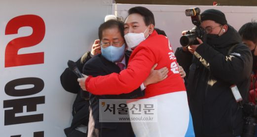 윤석열 국민의힘 대선 후보가 공식선거운동 첫날인 15일 대구 동구 동대구역 광장에서 열린 선거 유세에서 홍준표 의원과 포옹을 하고 있다.2022. 2. 15 김명국 선임기자