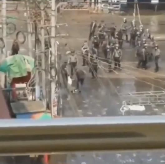 총에 맞아 숨진 시민을 경찰 2명이 끌고 가는 모습. 베란다에서 찍은 듯 철제 구조물이 화면 아래 보인다.[트위터 캡처]