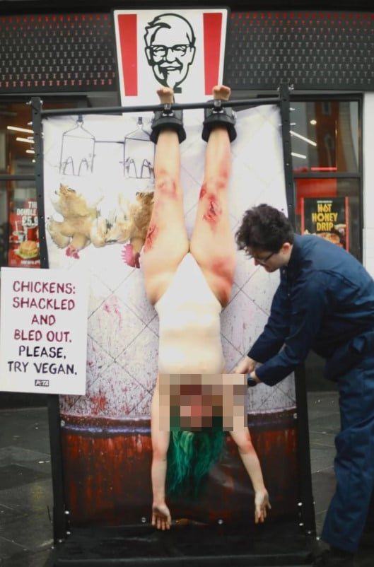 동물보호단체 PETA 소속 운동가들이 21일ㄹ 런던 램버스 브릭스턴 KFC 매장 앞에서 닭이 도살되는 방식을 알리는 퍼포먼스를 진행하고 있다./ PETA