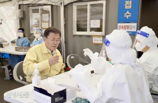 문재인 대통령이 설 연휴인 30일 오후 경기 안성휴게소(서울 방향)에 마련된 코로나19 임시 선별검사소를 방문해 김보라 안성시장 및 정혜숙 안성시 보건소장으로부터 현황 보고를 받고 신속항원검사 키트를 직접 사용해보고 있다. 청와대사진기자단. 2022.01.30