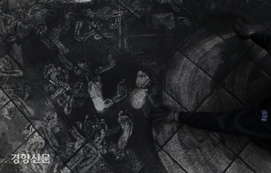 퍼모먼스 종료 후 탄가루를 청소하는 활동가. /김창길기자