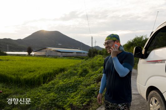 농사일을 마친 종수씨가 아내와의 통화 중 맥주를 사간다며 웃고 있다.