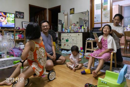 연희(6)랑 이야기 하는 종수씨와 독서삼매경에 빠진 17개월 막내 은재, 첫째 연아(9)의 머리카락을 잘라주는 은영씨.