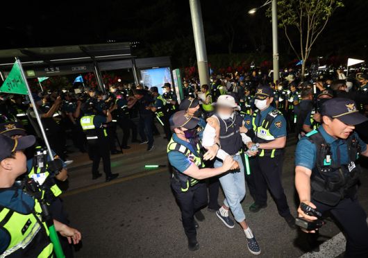 금속노조 조합원과 비정규직 노동단체 회원들이 25일 오후 서울 서초구 대법원 앞에서 열린 야간 문화제에서 이를 봉쇄하던 경찰과 대치 중 연행되고 있다. 연합뉴스