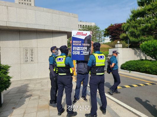 26일 경찰 3명이 서울 서초구 대법원 앞에서 1인 시위를 하고 있는 금속노조원 한명을 둘러싸고 있다. 이홍근 기자