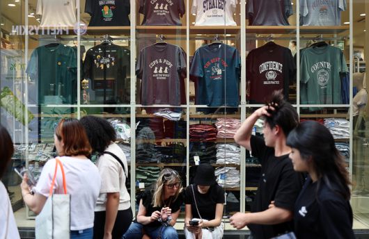 시민들이 6일 오후 서울 명동거리에서 의류 매장 앞을 지나고 있다. 연합뉴스