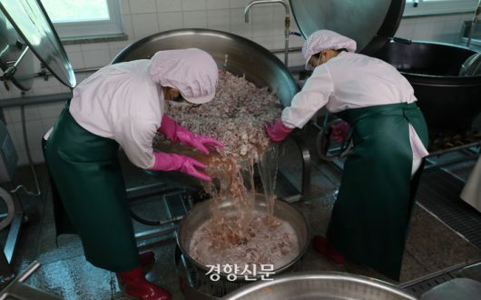 급식 조리사 두 명이 제육덮밥을 하기 위해 돼지고기를 삶은 물을 버리고 있다. 솥이 워낙 크고 무거워 두 명이서 하지 않으면 작업을 하기 어렵다.  서울특별시교육청 학교보건진흥원에 따르면 2019년 급식실에서 발생한 상해 중 가장 많은 것은 화상(31.1%)이었고, 상해 부위 중 가장 많은 부위는 손(34.4%)이었다.