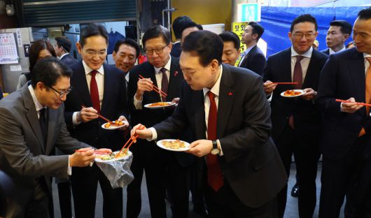 윤석열 대통령과 이재용 삼성전자 회장 등이 6일 부산 중구 깡통시장을 방문해 떡볶이를 시식하고 있다. 이날 부산항 국제 전시컨벤션센터에서 열린 ‘부산시민의 꿈과 도전’ 격려 간담회를 마친 뒤 재계 총수들과 이곳을 찾은 윤 대통령은 경기침체로 어려움을 겪고 있는 상인들을 응원하고 격려했다. 대통령실사진기자단