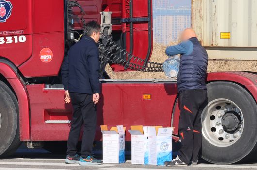 중국 당국이 한국으로의 산업용 요소 통관을 보류한 가운데 지난 4일 인천 연수구 인천신항 인근 도로변에서 대형화물차 운전기사가 요소수를 넣고 있다. 연합뉴스