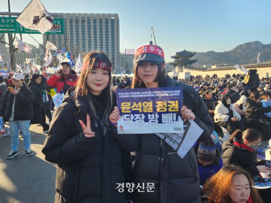 최별하씨(22·왼쪽)와 성시현씨(21)가 11일 오후 서울 광화문 앞에서 열린 ‘윤석열 체포·퇴진 범시민총궐기대회’에 참여해 손팻말을 들어보이고 있다. 오동욱 기자