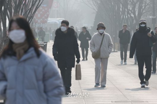 서울을 비롯한 수도권에 초미세먼지주의보가 내려진 지난 21일 서울 광화문 광장을 지나는 사람들이 마스크를 쓰고 있다. 정효진 기자