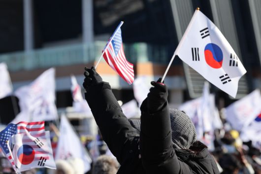 지난 2월 8일 울산 태화강역 광장에서 세이브코리아 울산운동본부 주최로 열린 윤석열 대통령 탄핵 반대 집회 참가자가 태극기와 성조기를 흔들고 있다./연합뉴스