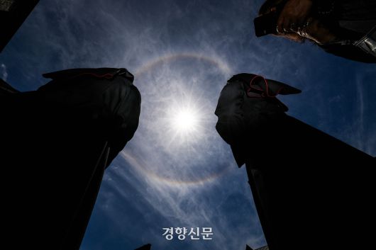 23일 서울 명동대성당에 마련된 프란치스코 교황 빈소 조문을 위해 기다리는 수녀님들 위로 원형의 무지개가 떠 있다. 조문을 기다리던 신도들은 “교황님께서 찾아오셨다”라며 무지개를 향해 기도를 올리거나 사진을 찍었다. 2025.4.23 이준헌 기자