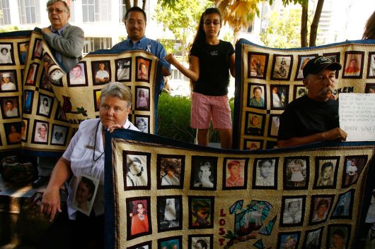 카톨릭 성직자에게 성적 피해를 당한 피해자들과 가족들이 2007년 7월 16일(현지시간) 로스엔젤레스 카운티 법원에서 다른 피해자들의 얼굴이 그려진 퀼트 이불을 들고 있다. 게티이미지