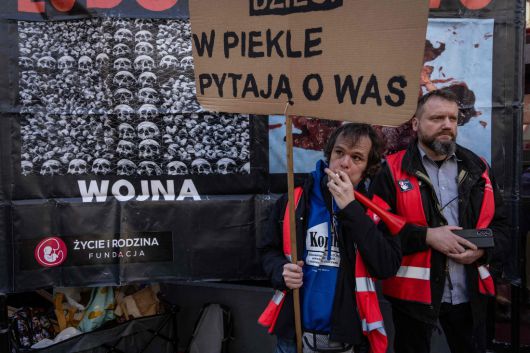 폴란드 바르샤바에 낙태 상담소가 개소한 다음 날인 지난 3월 8일(현지시간) 상담소 앞에서 열린 반낙태 시위에서 한 남성이 ‘지옥에서 당신을 찾고 있다’라고 적힌 팻말을 들고 있다. AFP연합뉴스