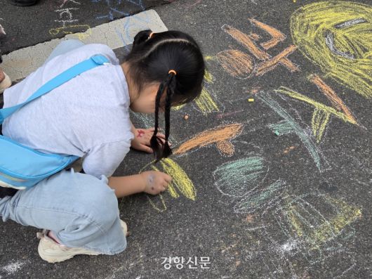 지난 17일 광주 동구 금남로에서 열린 5·18전야제에서 한 어린이가 아스팔트 바닥에 분필로 ‘광주 화이팅’이라고 쓰고 있다. 우혜림 기자