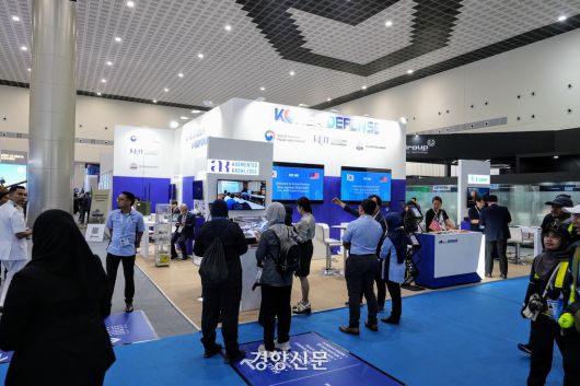 말레이시아 랑카위 방산전시회 ‘LIMA 2025’의 이튿날인 지난 21일(현지시간) 전시회 참가자들이 전시회장에 마련된 한국관 앞에서 참가업체 관계자의 설명을 듣고 있다. 한국방위산업진흥회 제공