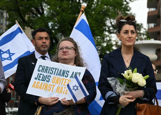 22일 미국 워싱턴의 수도 유대인 박물관 인근에서 총격으로 사망한 야론 리신스키와 사라 밀그림을 추모하기 위해 모인 사람들이 이스라엘 국기 등을 들고 있다. AFP연합뉴스