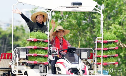김문수 국민의힘 대선후보가 지난 21일 경기 고양시 덕양구 화정동 일대 논에서 청년 농업인과 이앙기에 탑승해 모내기하며 손을 흔들고 있다. 한수빈 기자