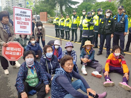 6개 시민·사회·종교 단체로 구성된 사드철회평화회의 회원들이 지난 15일 경북 칠곡군에 있는 주한미군 캠프캐롤 앞에서 ‘소성리 사드반대 현수막 훼손·절취 미군 범죄 규탄’ 기자회견을 열고 앉아 있다. 사드철회평화회의 제공