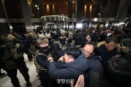 윤석열 전 대통령이 비상계엄을 선포한 후 자정을 넘긴 지난해 12월4일 새벽 서울 여의도 국회본청 앞에서 무장군인들이 진입을 시도하다 국회 직원 등 시민들에게 제지당하고 있다. 성동훈 기자