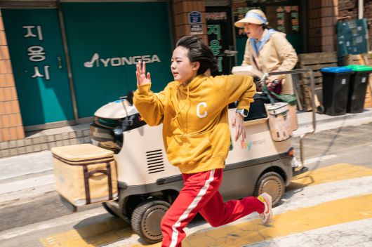 <하이파이브>의 ‘완서’(이재인)는 심장을 이식받은 뒤 빠른 스피드와 괴력을 얻게 된다. 영화 속 요구르트 후레시 매니저 ‘선녀’(라미란)가 탄 전동 카트보다도 완서가 빠르게 달리고 있다. NEW 제공