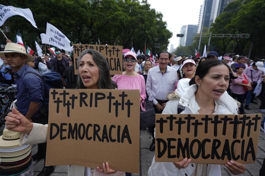 시위대가 1일(현지시간) 멕시코시티에서 열린 법관 직선제 반대 시위에서 ‘민주주의의 명복을 빈다’는 손팻말을 들고 구호를 외치고 있다. AP연합뉴스