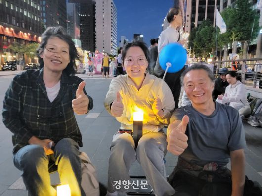 이미선(59·왼쪽부터)·위한슬(30)·위성계씨(61) 가족이 3일 서울 중구 청계과장에서 촛불행동 등이 주최한 개표방송 집회에 참가해 포즈를 취하고 있다. 김태욱 기자