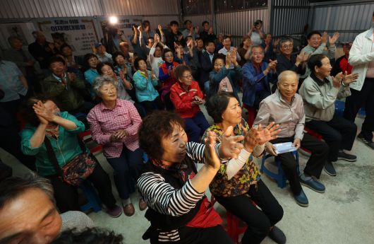 더불어민주당 이재명 대선 후보의 고향인 경북 안동시 예안면 도촌리의 경로당 창고에서 마을 주민들이 3일 제21대 대통령 선거 출구조사 결과를 확인하고 환호하고 있다. 연합뉴스