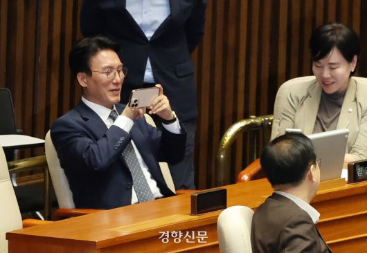 더불어민주당 4선 국회의원인 김민석 국무총리 지명자가 5일 국회 본회의장에서 본인 명패를 휴대폰으로 찍고 있다. 박민규 선임기자