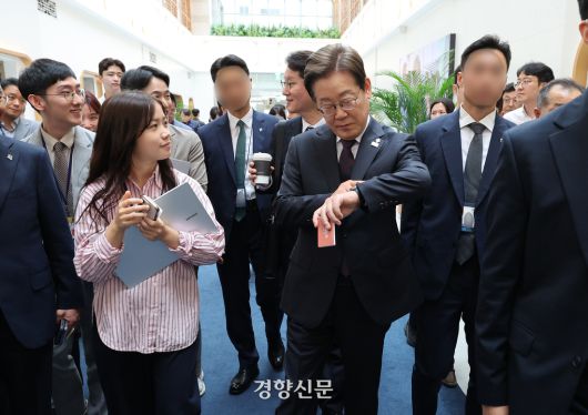 이재명 대통령이 10일 용산 대통령실 직원식당에서 식사를 마친 뒤 집무실로 돌아가며 취재진과 인사하다 시계를 들여다보고 있다. 대통령실사진기자단