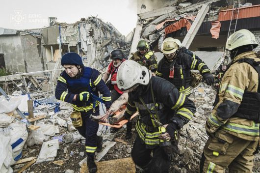10일(현지시간) 우크라이나 하르키우에서 러시아 로켓 공격으로 희생된 시신을 응급 서비스 요원들이 옮기고 있다. AP연합뉴스