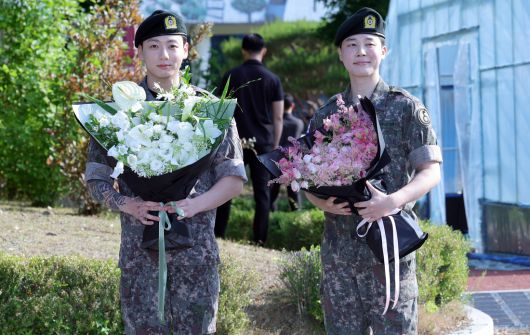 육군 병장으로 만기 전역한 BTS 지민과 정국이 11일 경기 연천군 연천공설운동장에서 열린 기념행사에서 팬들에게 인사하고 있다. 연합뉴스