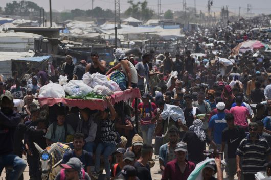 팔레스타인 사람들이 10일(현지시간) 가자지구 남부 라파에서 미국의 지원을 받는 가자 인도주의 재단(GHF)이 전달한 식량과 인도주의 지원 패키지가 담긴 가방을 들고 있다. AP연합뉴스