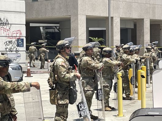 도널드 트럼프 대통령의 이민 단속에 항의하는 시위가 5일째 진행 중인 10일(현지시간) 미국 캘리포니아주 로스앤젤레스 다운타운의 연방 건물 앞에 주방위군이 배치돼 있다. 로스앤젤레스/김유진 특파원