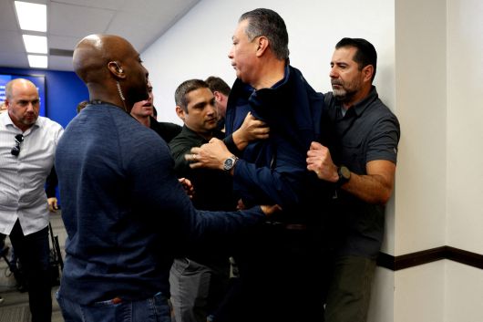 알렉스 파딜랴 미국 상원의원이 12일(현지시간) 캘리포니아주 로스앤젤레스 연방정부 청사에서 열린 크리스티 놈 국토안보장관 기자회견장에 들어가 질문을 던졌다가 연단에서 제지당하고 있다. 로이터연합뉴스