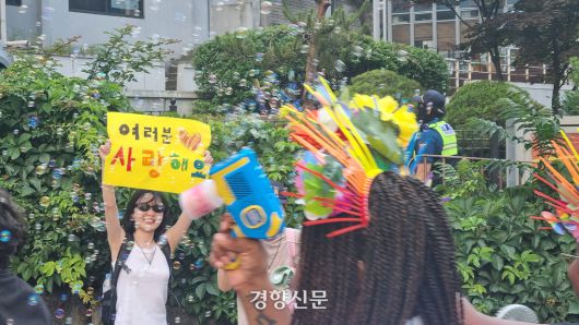 이정민씨(24)가 서울 중구 인권위원회 인근에서 노란 도화지에 손글씨로 ‘여러분 사랑해요’라고 써서 “사랑한다”고 외치고 있다. 강한들 기자