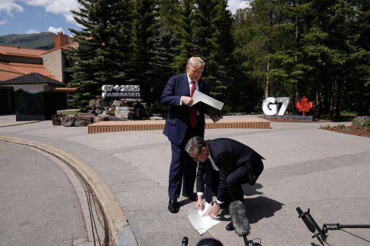 키어 스타머 영국 총리(오른쪽)가 16일(현지시간) 도널드 트럼프 미국 대통령이 떨어뜨린 미·영 무역협정 서류를 줍고 있다. AP연합뉴스