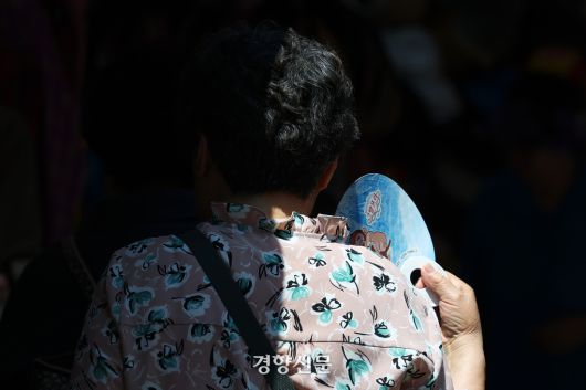 전국적으로 무더운 날씨를 보인 지난 23일 서울 중구 남대문시장을 찾은 시민이 부채질하고 있다. 정효진 기자