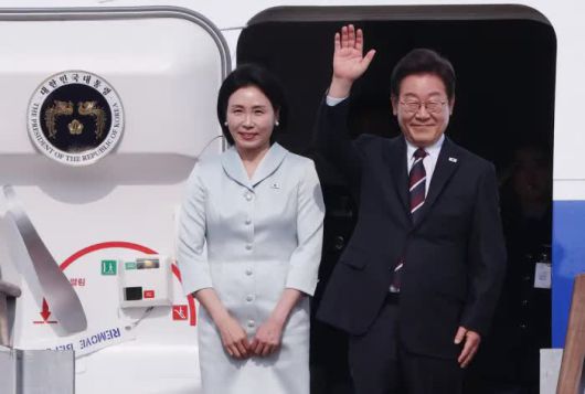 President Lee Jae-myung waves next to First Lady Kim Hye-kyung before boarding Air Force One at Seoul Airport in Seongnam, Gyeonggi Province, on June 16, ahead of their departure for the G7 Summit in Kananaskis, Alberta, Canada. / Reporter Kim Chang-gil