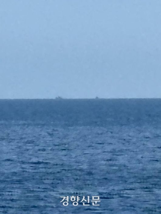 북한 주민을 태운 목선(수평선 오른쪽의 작은 점)이 예인용으로 추정되는 북한 어선(수평선 왼쪽 큰 점)과 함께 9일 오전 동해 북방한계선(NLL) 이북에서 이동하고 있다. 통일부 제공