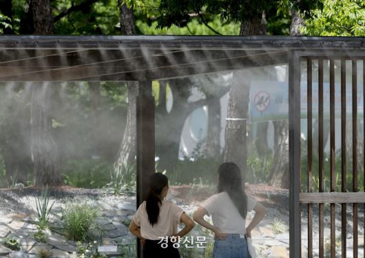 서울의 한낮 체감온도가 33도까지 오르는 등 무더위가 이어지고 있는 지난 1일 서울 여의도공원에서 시민들이 쿨링포그 벤치에 앉아 더위를 피하고 있다. 문재원 기자