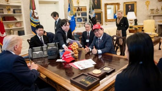 지난 4월 도널드 트럼프 미국 대통령을 만난 아자카와 료세이 일본 경제재생상이 마가(MAGA·미국을 다시 위대하게) 모자를 쓰고 있다. 로이터연합뉴스