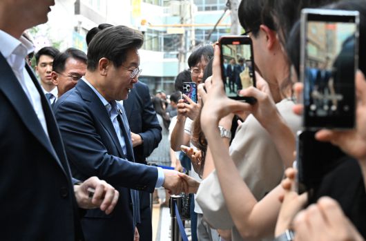 이재명 대통령이 11일 저녁 외식 행사를 하기 위해 찾은 서울 종로구의 한 식당 앞에서 시민들과 인사하고 있다. 대통령실사진기자단